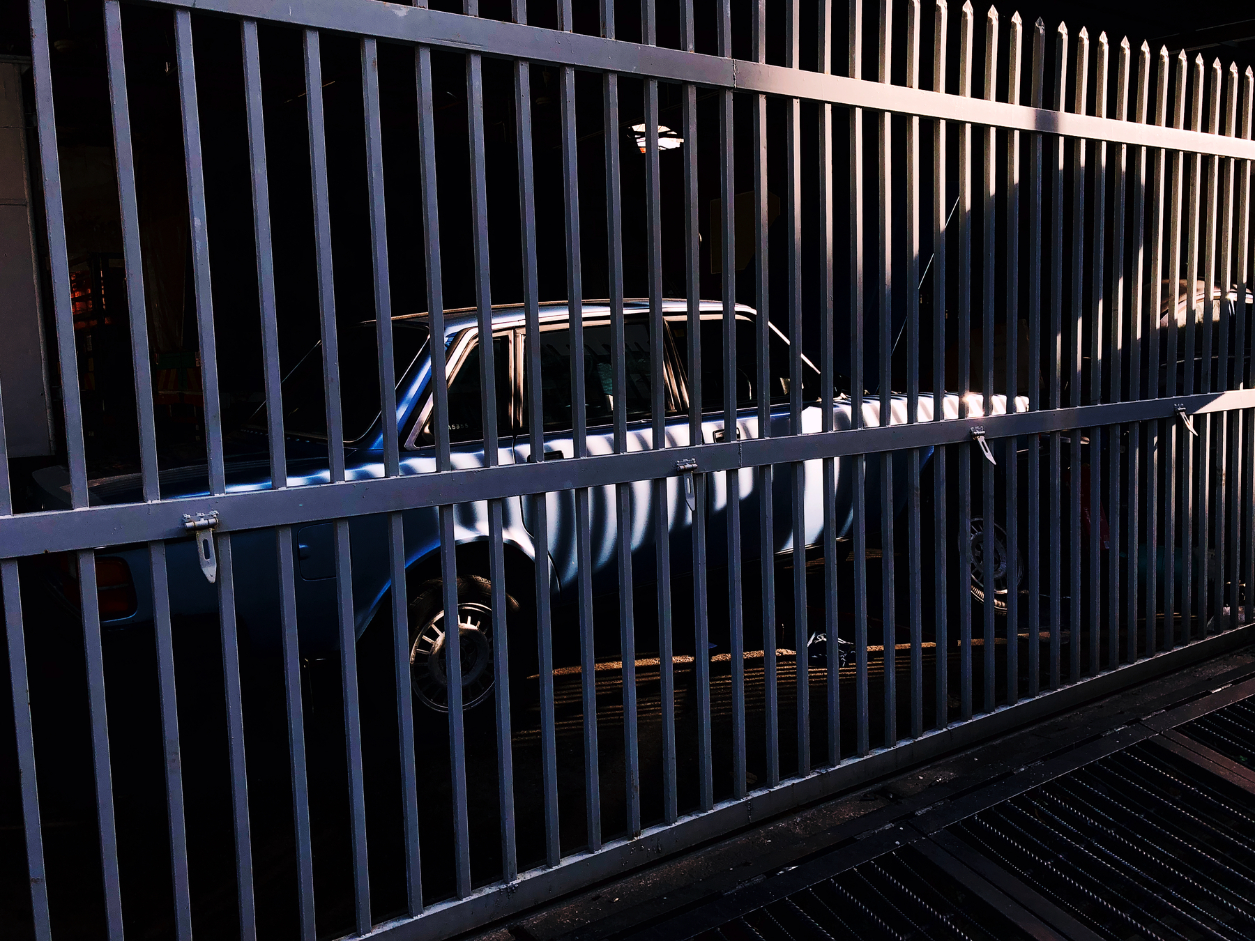 a car locked behind bars.