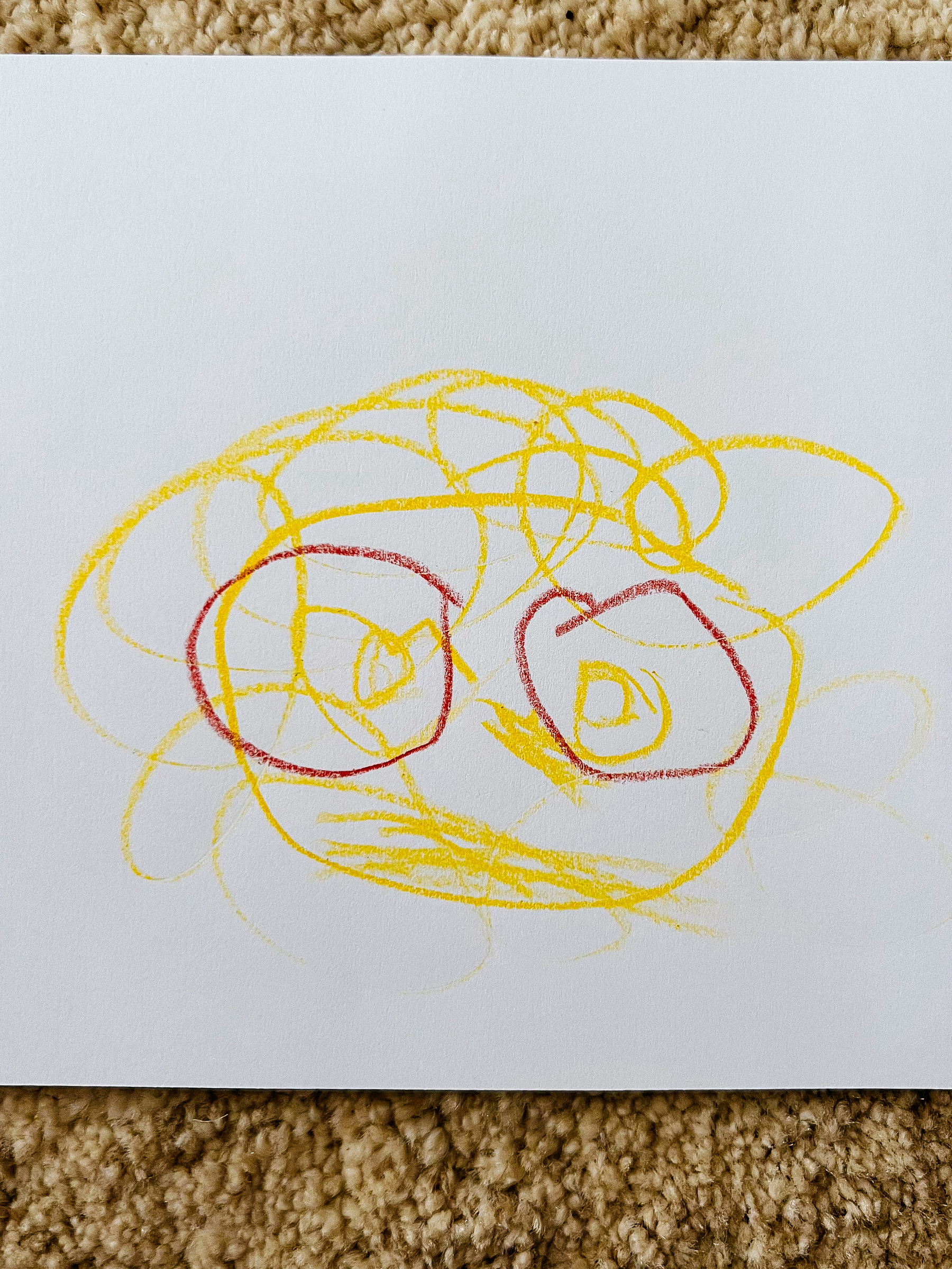 A kid’s drawing, very clearly showing an extremely handsome man, with crazy hair and big beard. He has a pair of red glasses. 