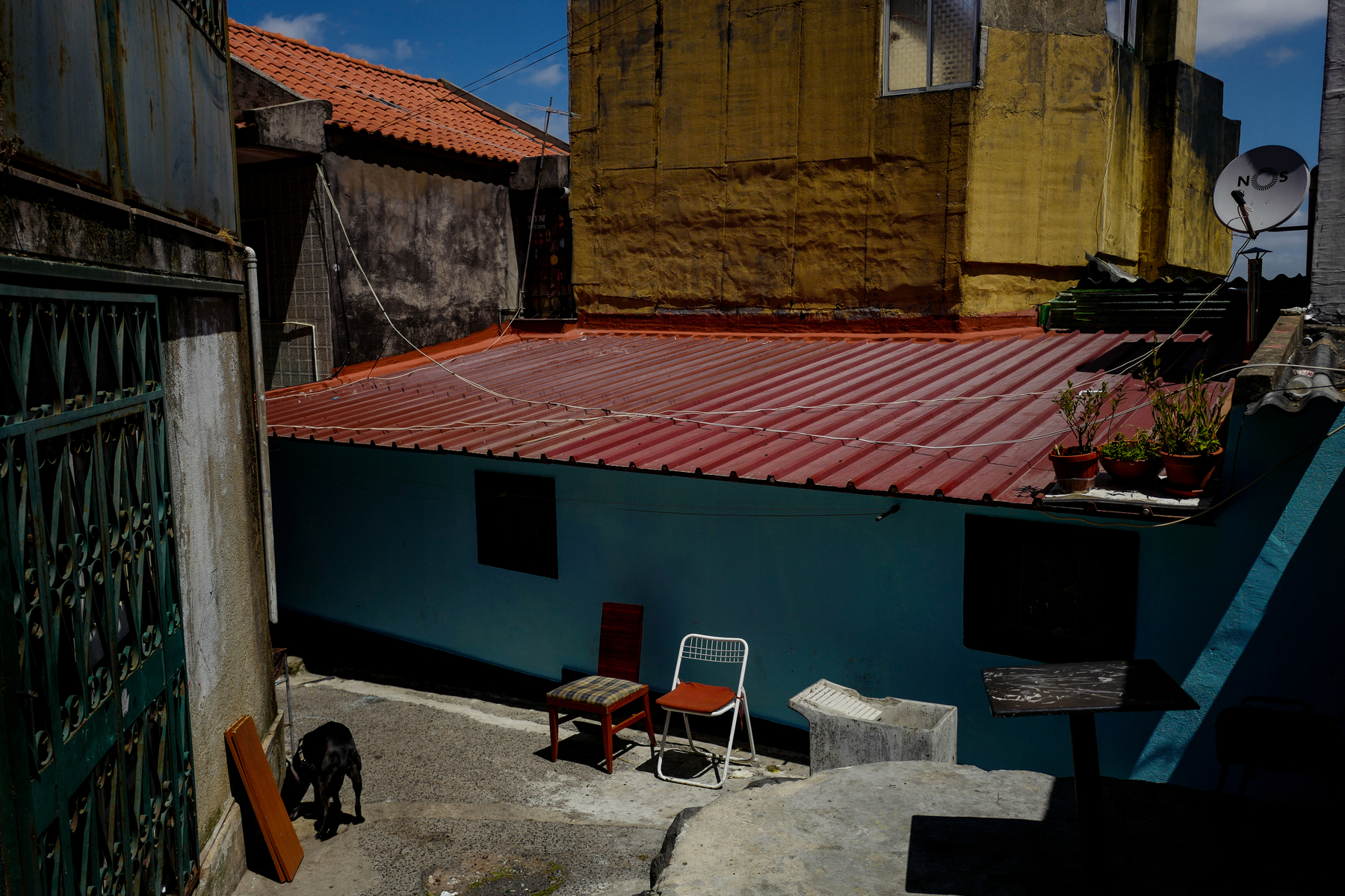 A couple of chairs sit quietly next to a couple of colorful houses. 