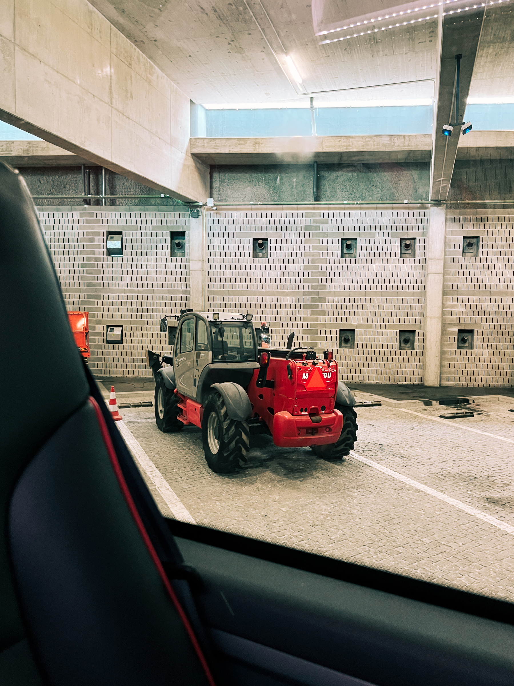 A tractor, parked inside the bus depot. 
