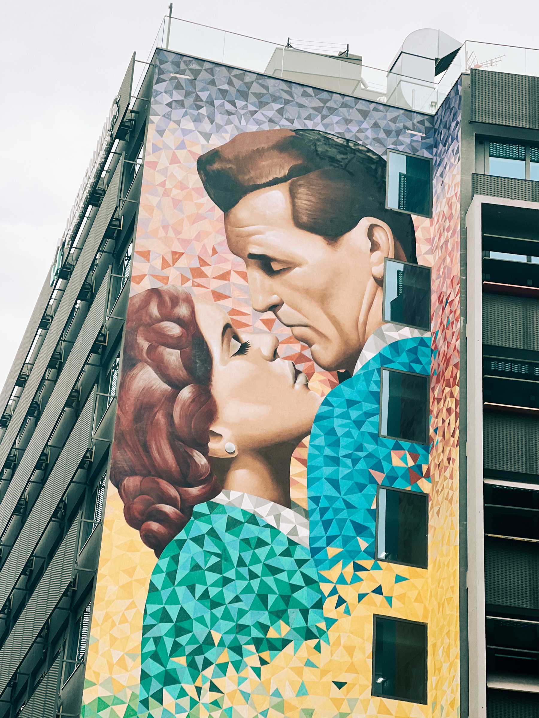 Street Art on the side of a building. A kiss.