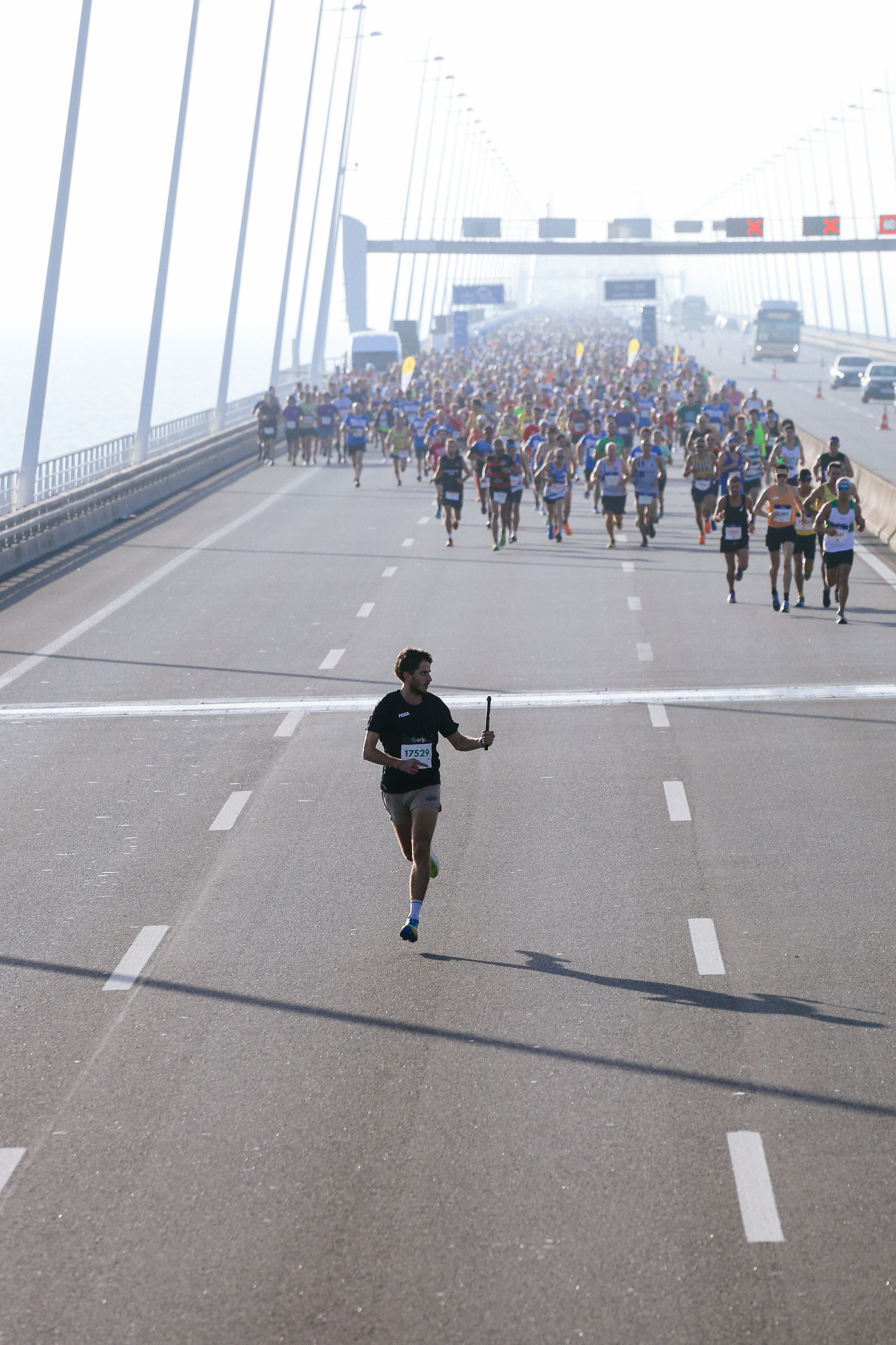 A man runs and shoots his GoPro camera, while runner follow close behind him. 