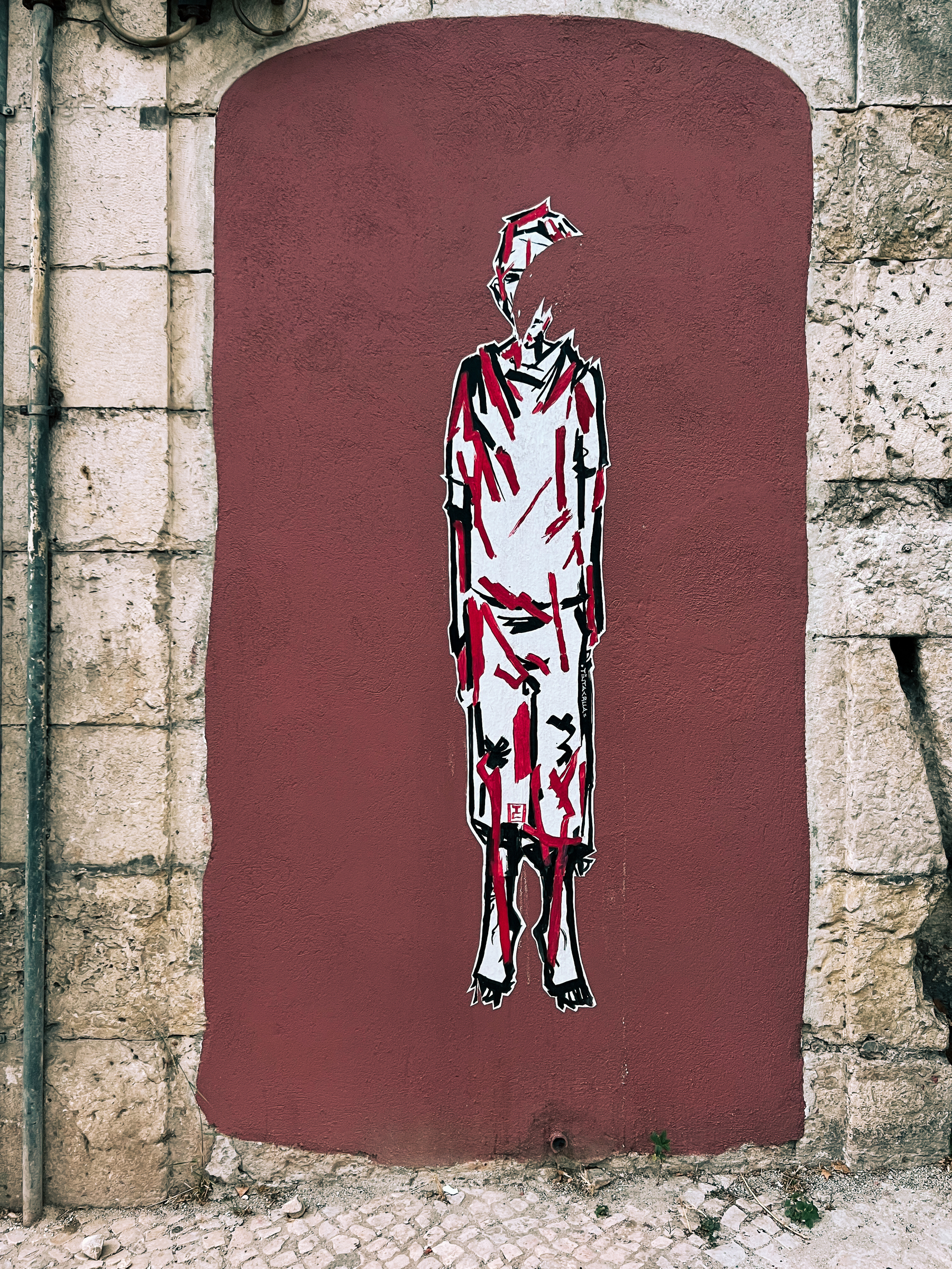 Street art piece, a figure of a man is plastered on a wall 
