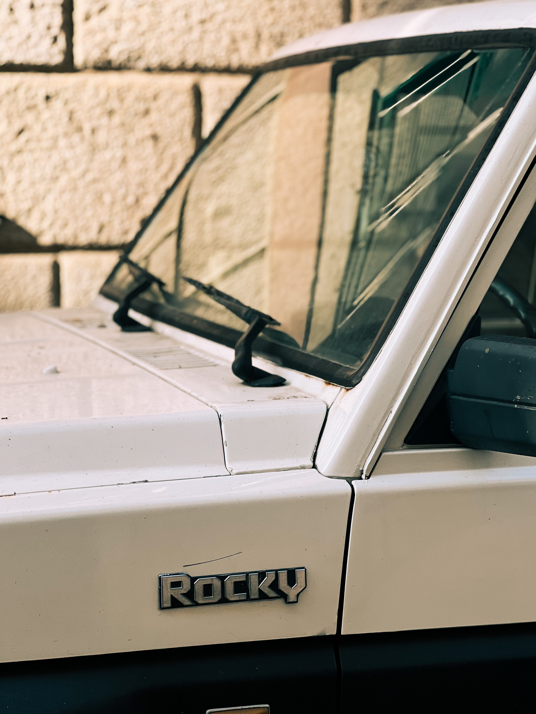 Detail of a jeep, the word “rocky”. 