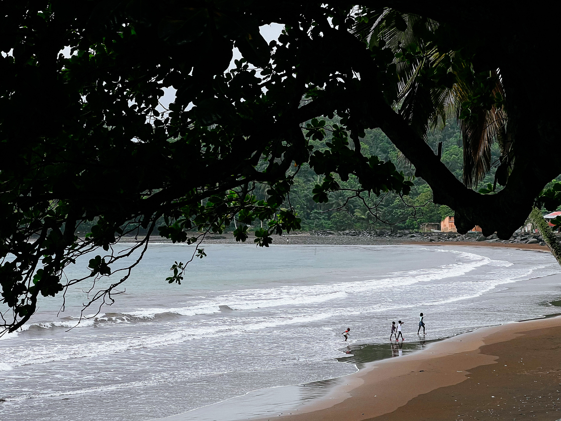 Children play on the beach, in a rainy day. 