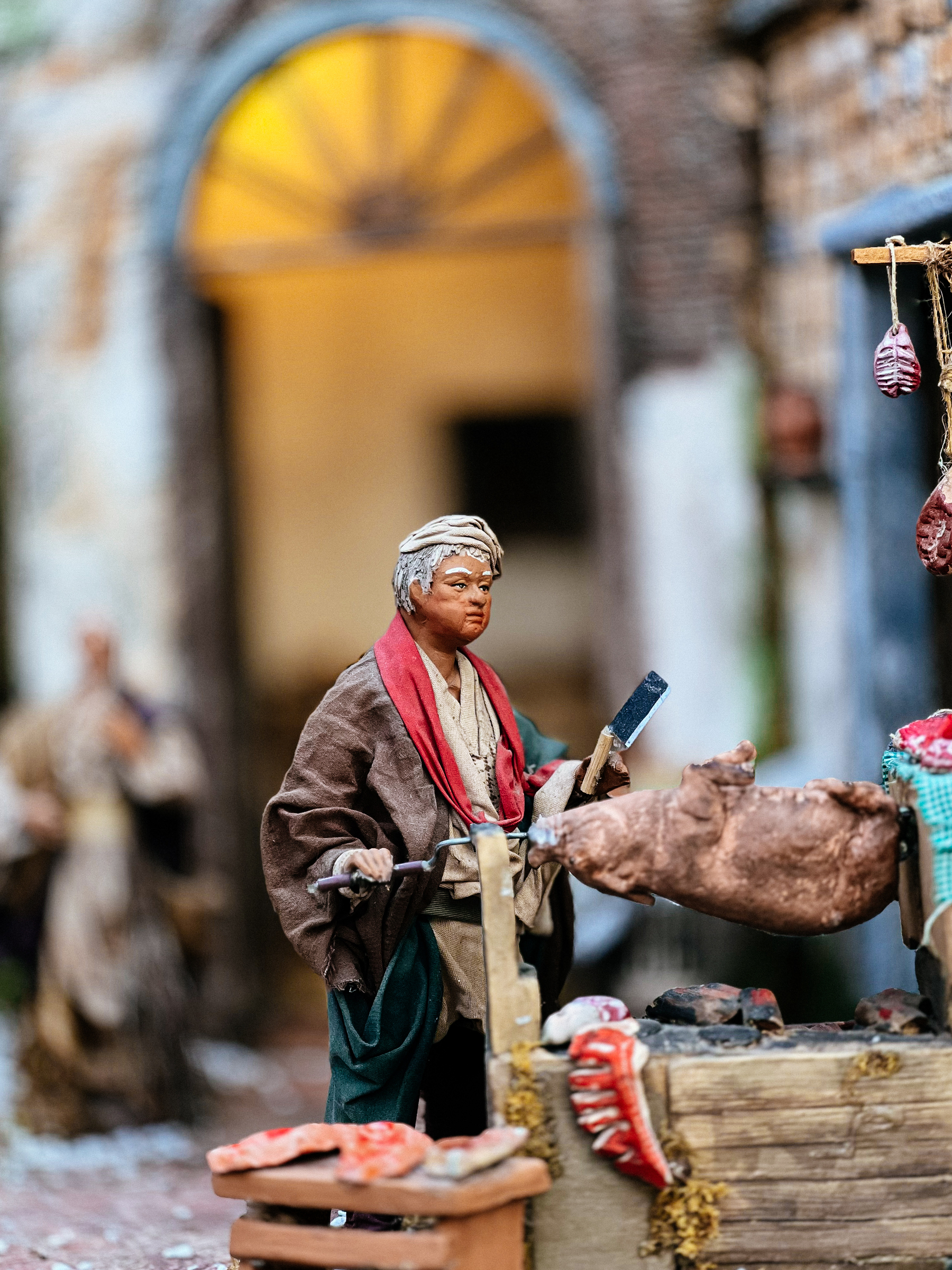 A character in a nativity scene. A man with a roasting pig. 