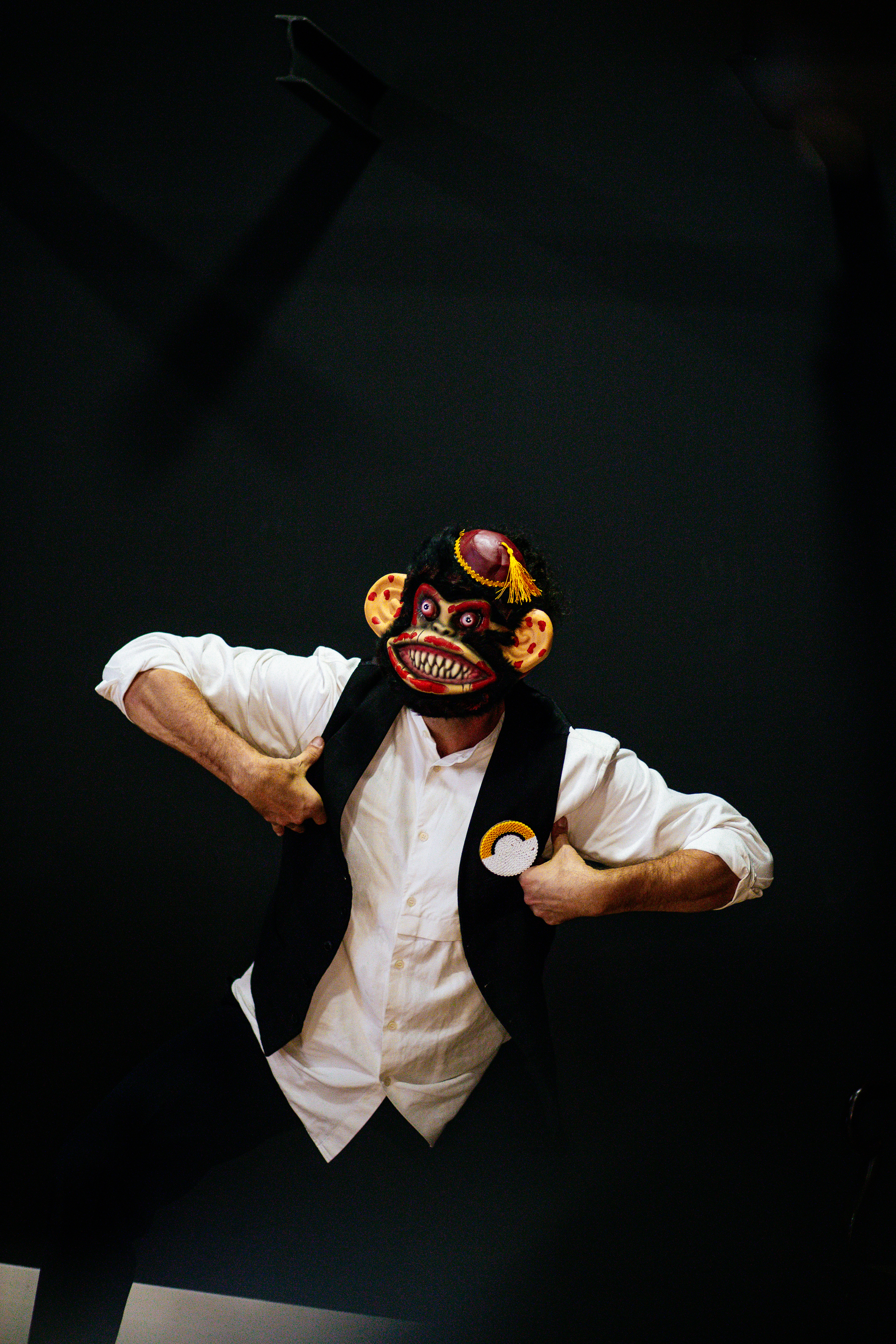 An artist dances around, dressed as a monkey.