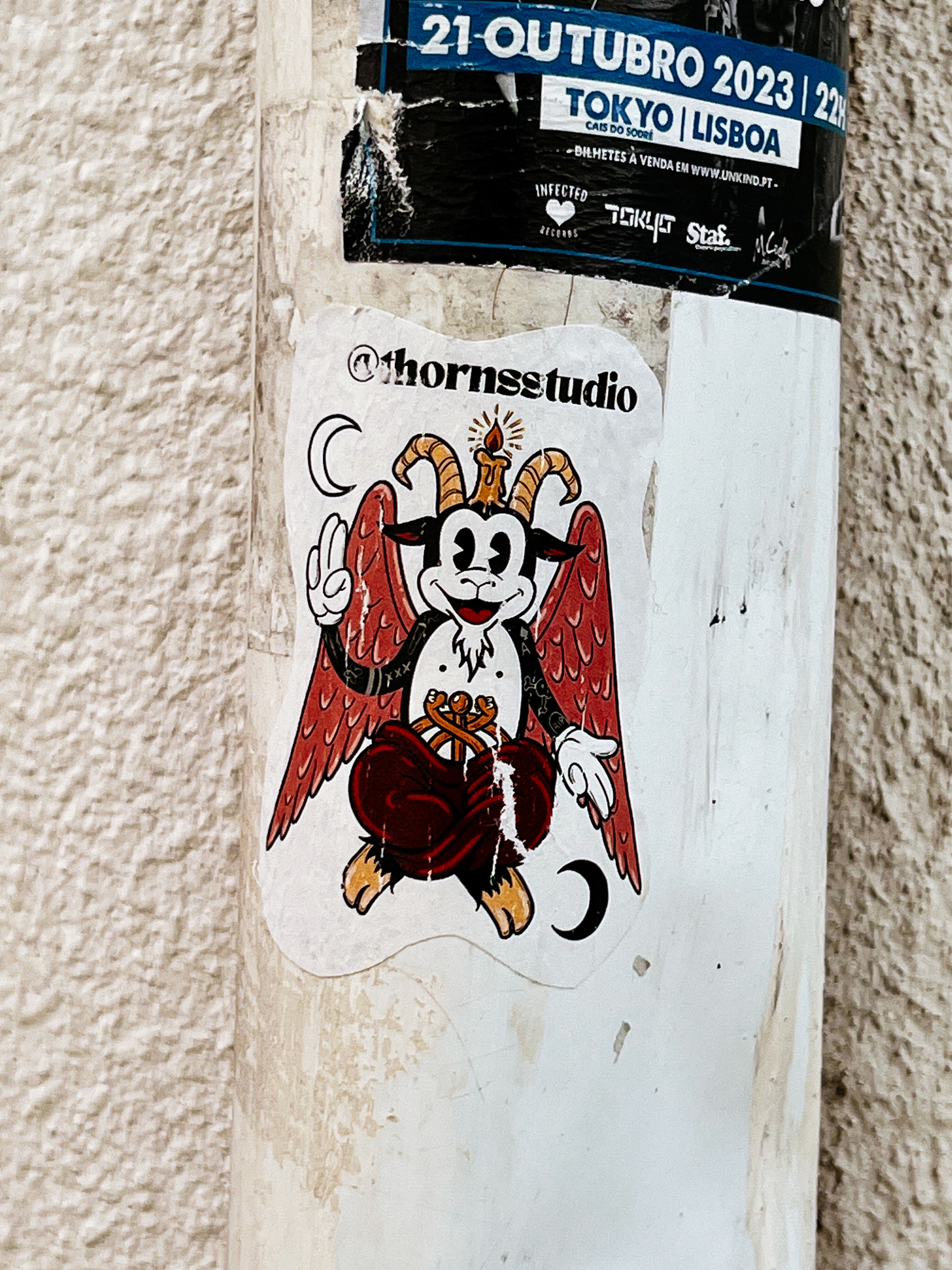 A smiling goat. Sitting cross legged, with wings, and a candle on the head. It&rsquo;s a sticker. 