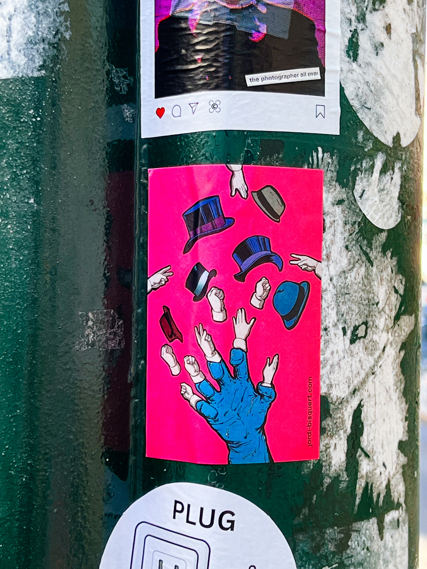 A sticker. There is a hand. Wearing one of those gloves with no fingertips. Each of the hand’s fingertips is another hand. And there are some hands not connected to the main hand. And hats. Lots of hats. 