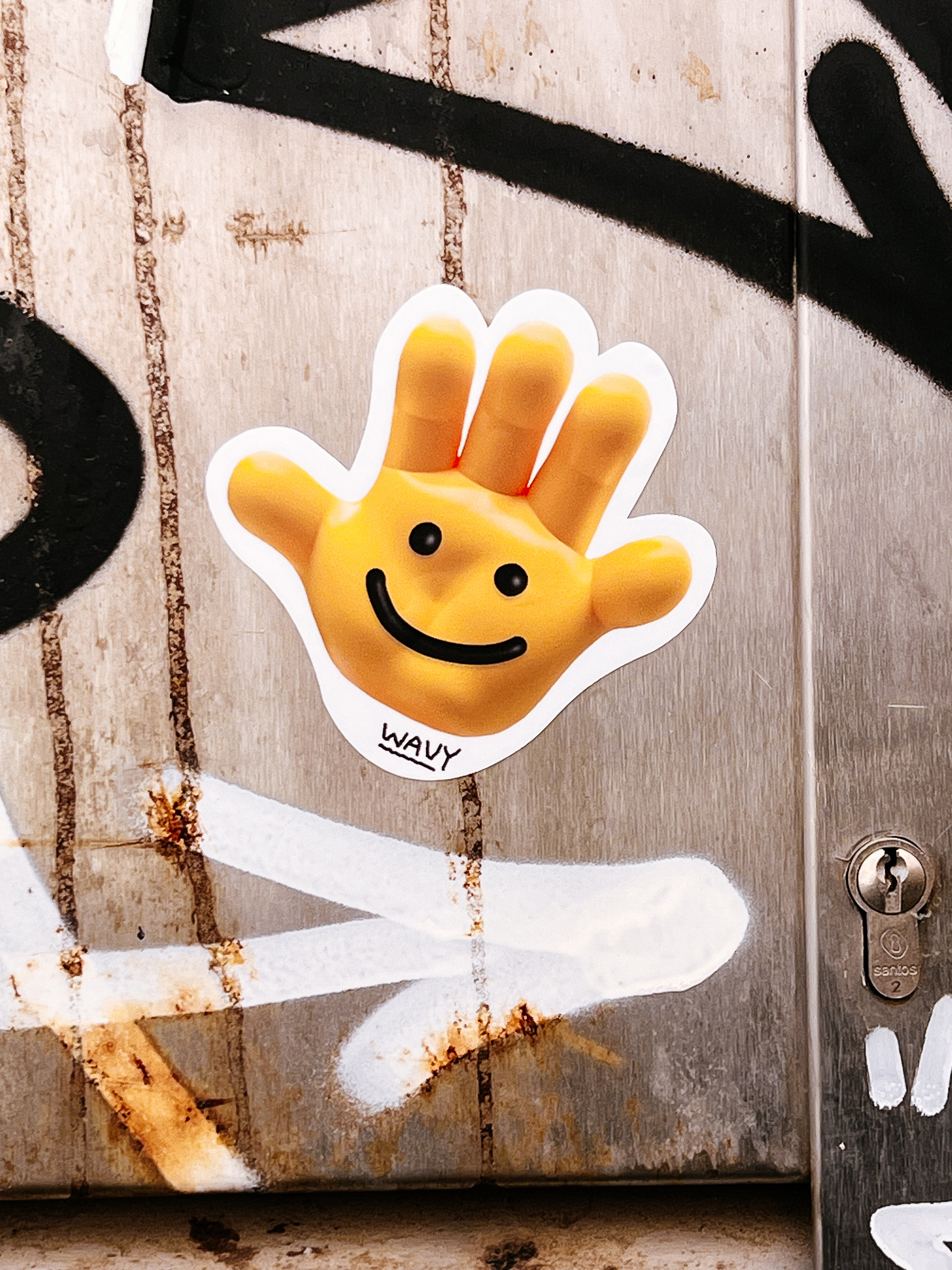 A yellow hand with eyes and a mouth, the word “wavy”. It’s a sticker. 